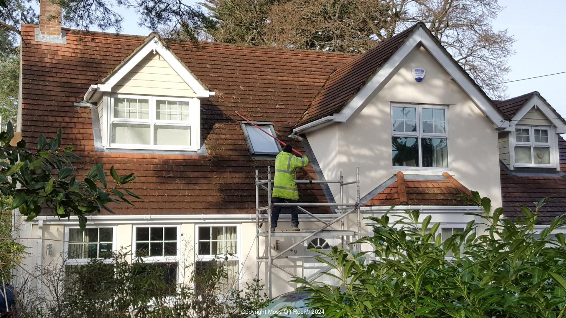 Roof cleaning in progress on cream property with red tiles and dormers