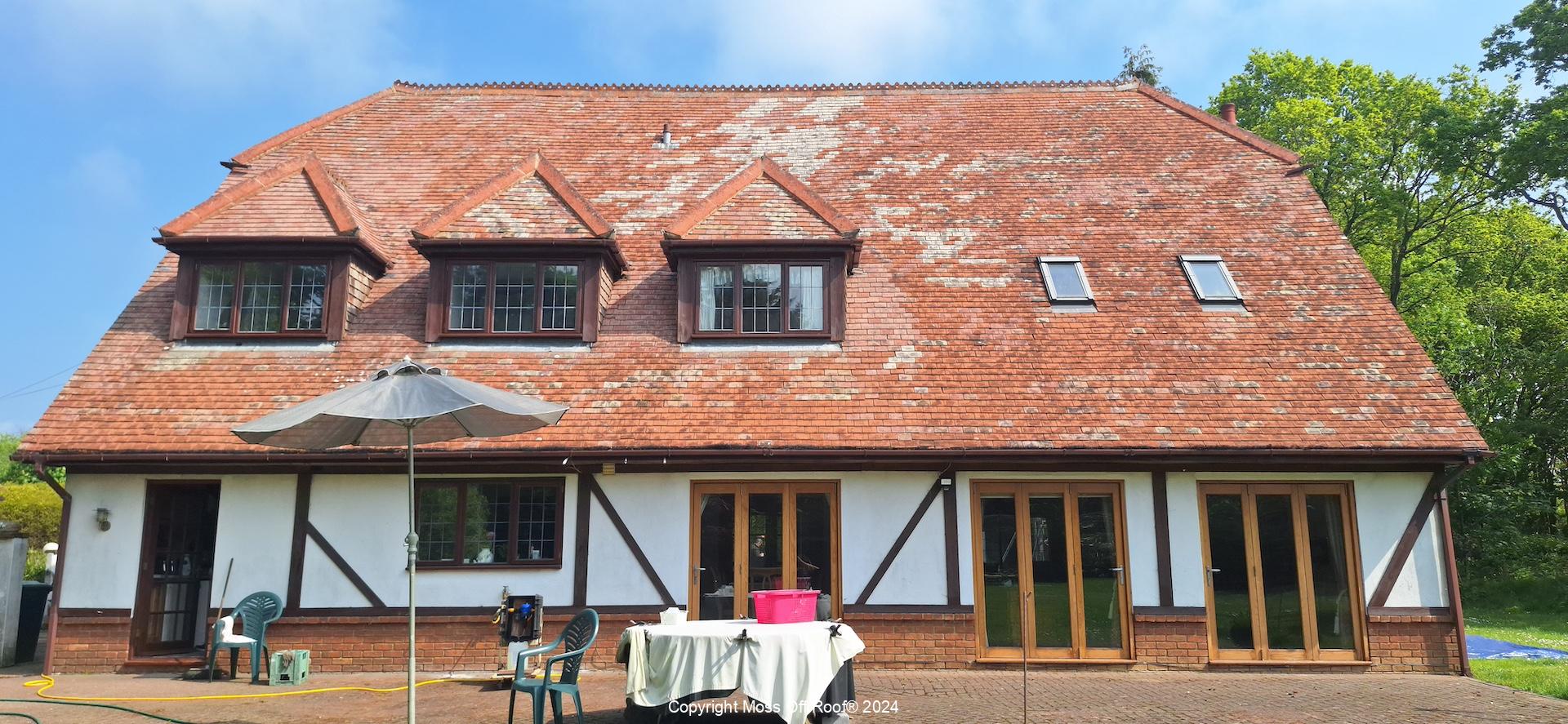 Light red tiled roof fully cleaned on large property with timber features