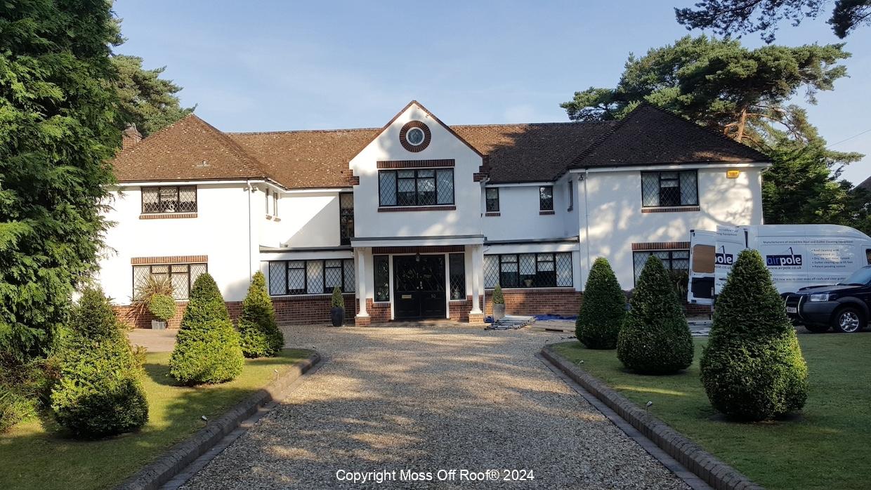 Front view of large white home with fully cleaned roof tiles